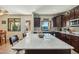 Bright kitchen with large island, granite countertops, dark cabinetry and view of the backyard pool at 41011 W Walker Way, Maricopa, AZ 85138