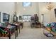 Large living room featuring many pinball machines, high ceilings, a chandelier and natural light from multiple windows at 41011 W Walker Way, Maricopa, AZ 85138