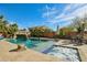 Beautiful in ground pool with waterfall, hot tub, and surrounding landscaping at 41011 W Walker Way, Maricopa, AZ 85138