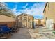 The backyard features a storage shed for storing tools, equipment, or converting it into a playhouse at 41011 W Walker Way, Maricopa, AZ 85138