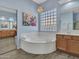 Elegant bathroom featuring a soaking tub, double vanity, and stylish tile flooring at 4215 W Reddie Loop, Phoenix, AZ 85083
