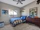 Bedroom with a large window, ceiling fan, carpet, and a dresser with decorations at 4215 W Reddie Loop, Phoenix, AZ 85083