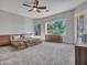 Bright main bedroom with an eye-catching ceiling fan, carpet floors, and ample natural light at 4215 W Reddie Loop, Phoenix, AZ 85083