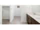 Bathroom featuring double sinks, stylish cabinets, tile floor, and an adjacent walk-in closet at 4351 W Jeanette Ln, San Tan Valley, AZ 85144