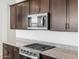 Kitchen view showcasing granite countertop, stainless steel stove top and microwave, and dark wood cabinets at 4351 W Jeanette Ln, San Tan Valley, AZ 85144