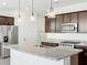 Kitchen with dark cabinets, stainless steel appliances, and a large island with a sink at 4351 W Jeanette Ln, San Tan Valley, AZ 85144
