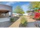 A view of the peaceful backyard with desert landscaping, a covered patio, and blooming vegetation at 4624 W Heyerdahl Ct, New River, AZ 85087