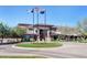 Exterior view of the community clubhouse displaying manicured landscaping, a circular drive, and flagpoles at 4624 W Heyerdahl Ct, New River, AZ 85087