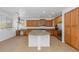 Bright eat-in kitchen featuring wooden cabinets, stone countertops, stainless steel appliances, an island, and a desk at 4624 W Heyerdahl Ct, New River, AZ 85087