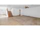 Open-concept living area with neutral tiling and carpet, and a view towards a wooden staircase at 4624 W Heyerdahl Ct, New River, AZ 85087