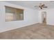 Spacious main bedroom with neutral carpet, ceiling fan, a window with wooden blinds, and an arched doorway to the en suite at 4624 W Heyerdahl Ct, New River, AZ 85087