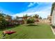 Backyard featuring artificial turf, patio shade, and lawn games at 5048 S Dante --, Mesa, AZ 85212