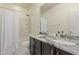 Bright bathroom featuring a double sink vanity with a marble countertop and a shower with a white curtain at 5048 S Dante --, Mesa, AZ 85212