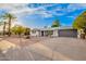 Charming single-story home with low maintenance desert landscaping and a gray two car garage door at 5725 E Colby St, Mesa, AZ 85205