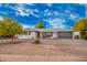 Charming single-story home with low maintenance desert landscaping and a gray two car garage door at 5725 E Colby St, Mesa, AZ 85205