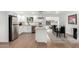 Modern kitchen featuring white cabinetry, stainless steel appliances, quartz countertops, and a view into dining area at 5725 E Colby St, Mesa, AZ 85205