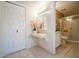 Hallway view of the bathroom with tile floors, vanity and sink, and a shower with glass doors at 6020 E Shea Blvd, Scottsdale, AZ 85254