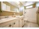 Well-lit bathroom featuring a double sink vanity, a tub/shower, and decorative starfish accents at 6020 E Shea Blvd, Scottsdale, AZ 85254