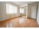 Bright bedroom with wood floors, large window with blinds, and mirrored closet at 6020 E Shea Blvd, Scottsdale, AZ 85254