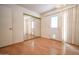 Cozy bedroom with wood flooring, mirrored closet, and sliding glass door to outside at 6020 E Shea Blvd, Scottsdale, AZ 85254