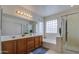 Well-lit bathroom featuring double sinks, soaking tub, walk-in shower, and modern fixtures at 6614 E Portia St, Mesa, AZ 85215