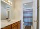 Well-lit bathroom featuring a wood vanity and a shower/toilet area at 6614 E Portia St, Mesa, AZ 85215