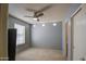 Neutral bedroom with a ceiling fan, window with blinds, carpet, and ensuite bathroom visible through the open door at 6614 E Portia St, Mesa, AZ 85215