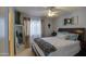 Comfortable bedroom with a ceiling fan, a decorative cross, a window, and a mirror at 6614 E Portia St, Mesa, AZ 85215