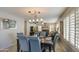Inviting dining room with stylish chandelier and comfortable seating, flowing into a spacious living area at 6614 E Portia St, Mesa, AZ 85215