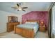 Cozy primary bedroom with ceiling fan, wooden furniture, and a serene atmosphere for restful nights at 6614 E Portia St, Mesa, AZ 85215