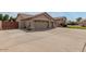 Wide driveway leading to a three-car garage, complemented by desert landscaping and a partial view of the home at 7047 W Saint John Rd, Glendale, AZ 85308