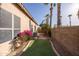 Landscaped backyard featuring a putting green, tropical trees, and desert foliage at 7452 W Los Gatos Dr, Glendale, AZ 85310
