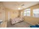 Bright bedroom with a ceiling fan, large window and colorful bedspread at 7452 W Los Gatos Dr, Glendale, AZ 85310