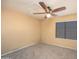 Unfurnished bedroom featuring neutral walls, carpet, ceiling fan and window at 7452 W Los Gatos Dr, Glendale, AZ 85310
