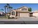 Charming two-story home featuring a neutral exterior, a well-manicured lawn, desert landscaping, and a two-car garage at 7452 W Los Gatos Dr, Glendale, AZ 85310