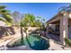 Backyard pool and patio with desert landscaping, covered porch and grill at 7452 W Los Gatos Dr, Glendale, AZ 85310