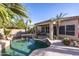 Backyard pool and patio with desert landscaping, covered porch and grill at 7452 W Los Gatos Dr, Glendale, AZ 85310