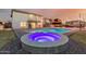 Inviting backyard with illuminated hot tub, sparkling pool, and cozy patio area, perfect for evening relaxation at 7953 W Topeka Dr, Glendale, AZ 85308