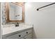 Charming powder room with a decorative mirror, granite countertop, and classic fixtures at 7953 W Topeka Dr, Glendale, AZ 85308