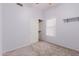 Carpeted bedroom with large window, fan, and closet with sliding doors at 7953 W Topeka Dr, Glendale, AZ 85308