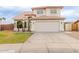 Two-story home featuring a tile roof, arched entryway, well-manicured lawn, and a two-car garage at 7953 W Topeka Dr, Glendale, AZ 85308