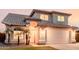 Two-story home featuring a tile roof, arched entryway, well-manicured lawn, and a two-car garage at 7953 W Topeka Dr, Glendale, AZ 85308