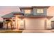 Two-story home featuring a tile roof, arched entryway, well-manicured lawn, and a two-car garage at 7953 W Topeka Dr, Glendale, AZ 85308