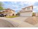 View of a two-story house with a tile roof, two-car garage, driveway, and landscaping at 7953 W Topeka Dr, Glendale, AZ 85308