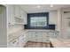 Bright, spacious kitchen with plentiful white cabinetry, granite countertops, and large window with a view at 7953 W Topeka Dr, Glendale, AZ 85308