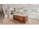 Spacious kitchen features a large center island, white cabinetry, stainless steel appliances, and granite countertops at 7953 W Topeka Dr, Glendale, AZ 85308