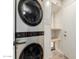 Efficient laundry area featuring a stacked washer and dryer, and built-in shelving for optimal organization at 7953 W Topeka Dr, Glendale, AZ 85308