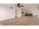 Open-concept living room with wood-look tile floors leading to the kitchen and dining area at 7953 W Topeka Dr, Glendale, AZ 85308