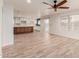 Open-concept living room with wood-look tile floors leading to a kitchen and sliding glass doors at 7953 W Topeka Dr, Glendale, AZ 85308