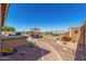 Landscaped backyard with rock ground cover, a built-in grill, and outdoor seating area at 8176 E Sweet Bush Ln, Gold Canyon, AZ 85118